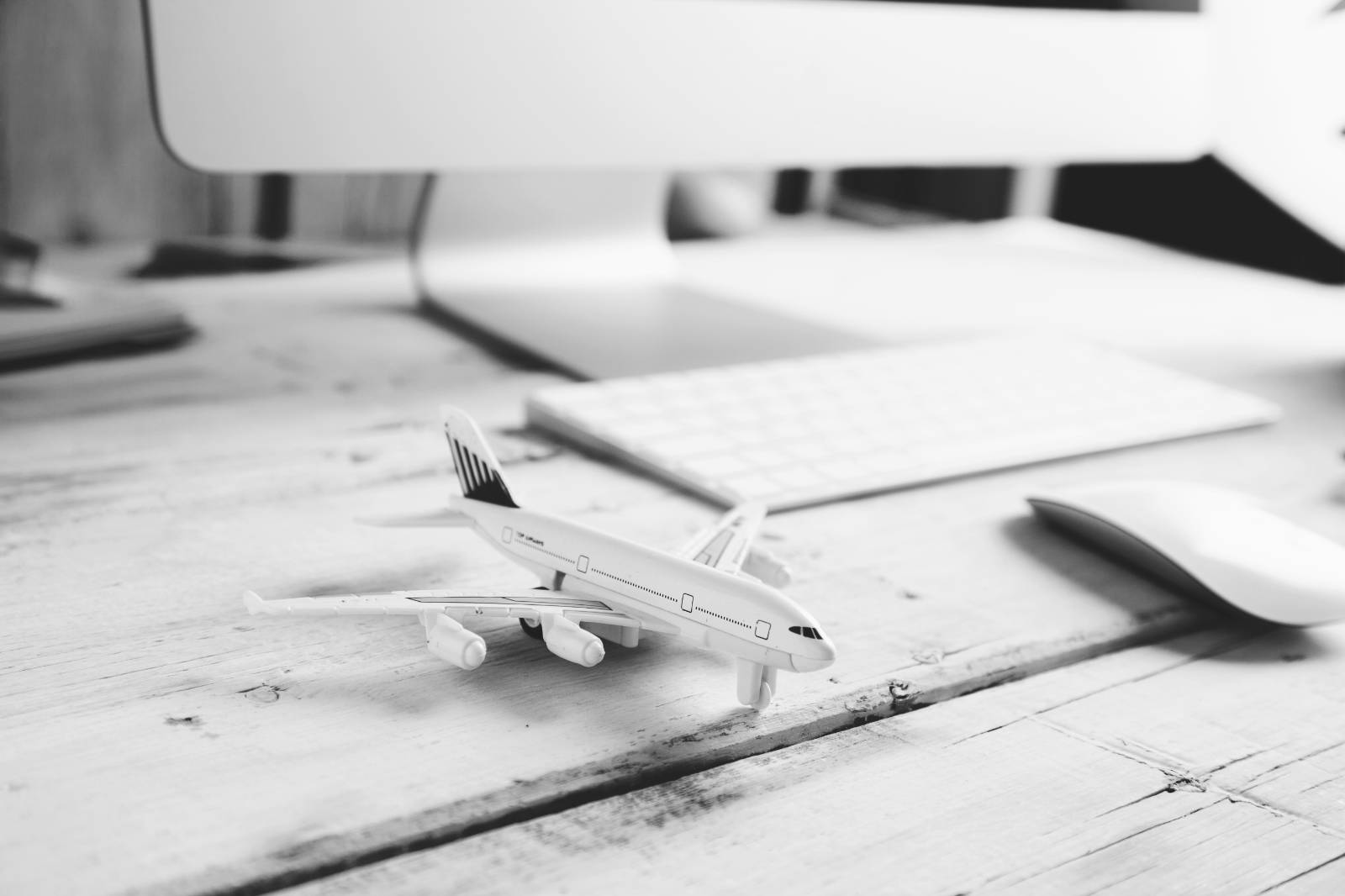 Un modellino di aereo su una scrivania accanto a una tastiera